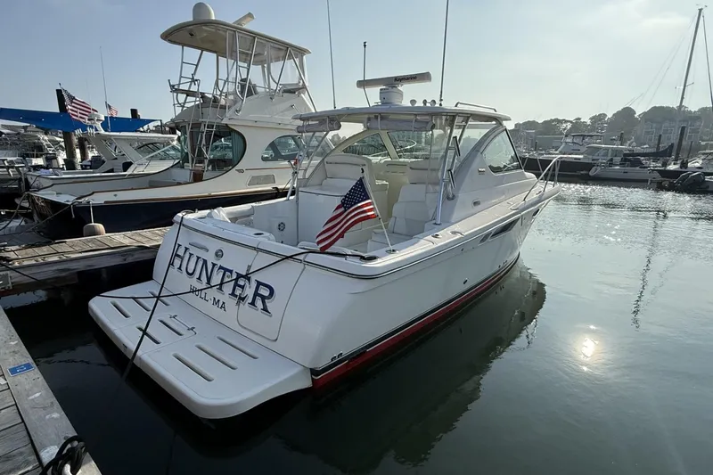 Slide: The Image of 2008 Tiara Yachts 3000 Open docked, displaying American flag, sunny marina setting. - 3