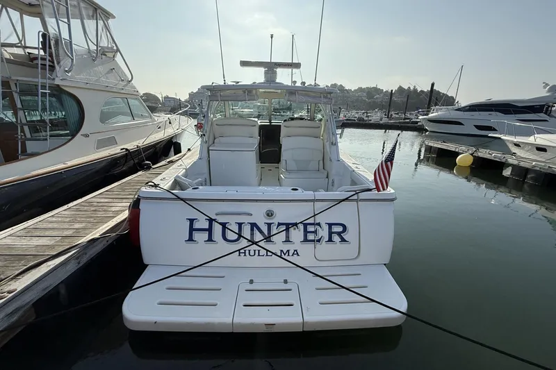Slide: The Image of 2008 Tiara Yachts 3000 Open docked, displaying "HUNTER" and American flag. - 4
