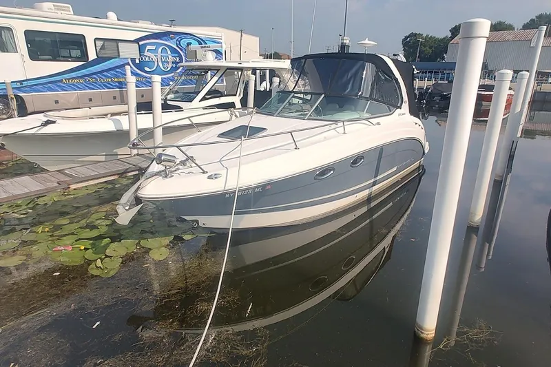 The Image of 2015 Chaparral 270 Signature boat docked at marina, surrounded by lily pads. - 0