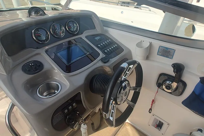 Slide: The Image of 2015 Chaparral 270 Signature boat dashboard with steering wheel and control panel. - 10