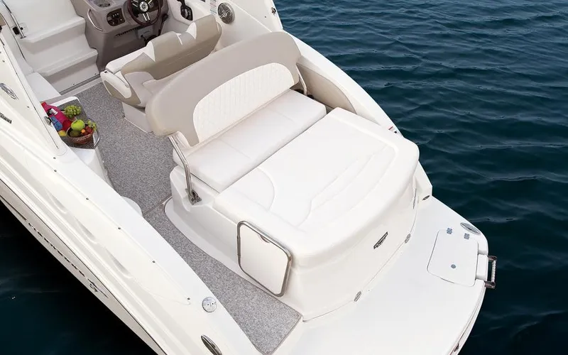 Slide: The Image of Manufacturer Provided Image: 2015 Chaparral 270 Signature boat with white seating and helm, on water. - 16
