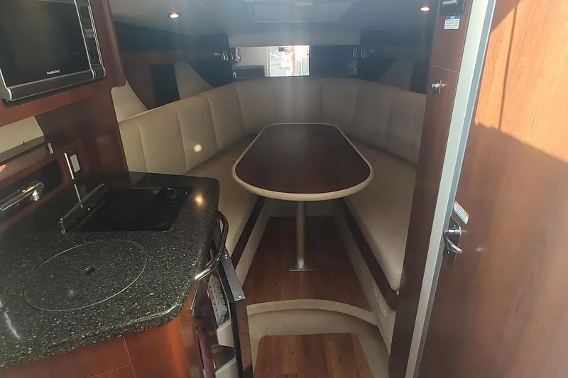 Slide: The Image of Interior of 2015 Chaparral 270 Signature boat with seating and kitchenette. - 21