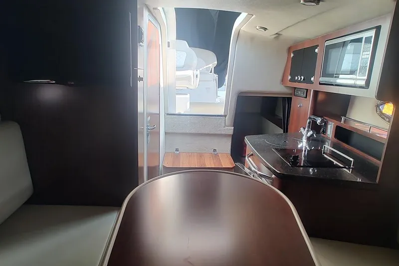Slide: The Image of Interior of 2015 Chaparral 270 Signature boat with kitchenette and seating area. - 23