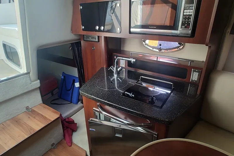 Slide: The Image of 2015 Chaparral 270 Signature boat interior with kitchenette, microwave, and compact design. - 24