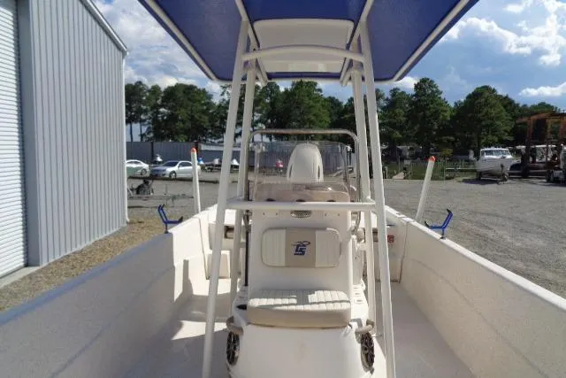 Slide: The Image of 2018 Carolina Skiff 258 DLV boat with blue canopy, parked outdoors. - 14