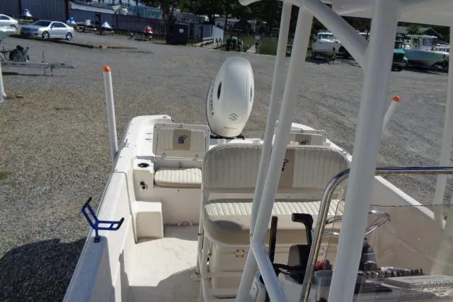Slide: The Image of 2018 Carolina Skiff 258 DLV boat with seating and motor, parked on gravel. - 16
