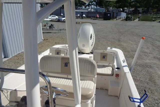 Slide: The Image of 2018 Carolina Skiff 258 DLV boat interior with seating and motor, parked outdoors. - 17