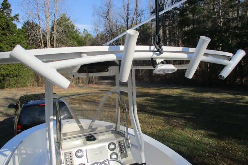 Slide: The Image of 2018 Carolina Skiff 258 DLV boat with T-top and rod holders in a wooded area. - 21