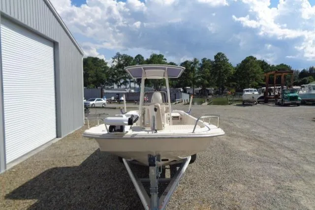 Slide: The Image of 2018 Carolina Skiff 258 DLV boat on trailer, parked outdoors near a warehouse. - 3