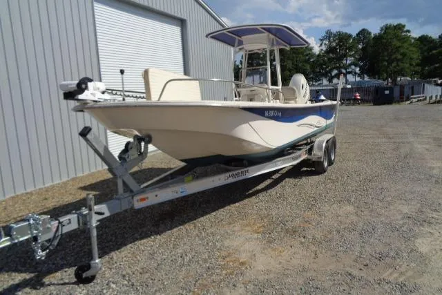 Slide: The Image of 2018 Carolina Skiff 258 DLV boat on trailer, parked outside a metal building. - 4
