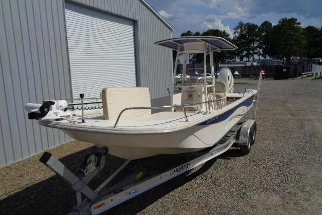 Slide: The Image of 2018 Carolina Skiff 258 DLV boat on trailer, parked near a metal building. - 5
