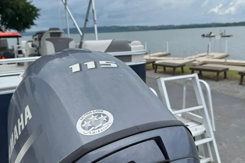 Slide: The Image of Yamaha 115 outboard motor on 2024 Avalon VENTURE 85 QUAD LOUNGER, near a lakeside dock. - 3