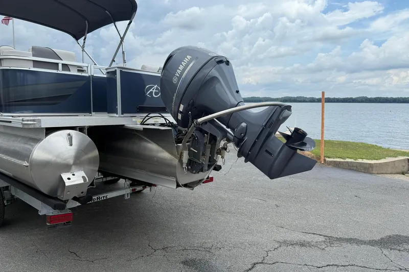 Slide: The Image of 2024 Avalon VENTURE 85 QUAD LOUNGER pontoon boat with Yamaha outboard motor by a lake. - 4
