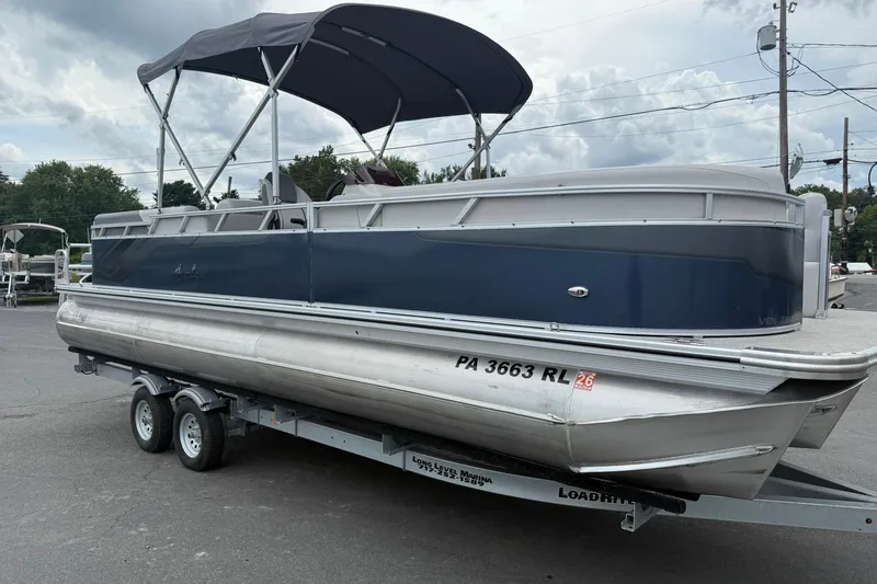 Slide: The Image of 2024 Avalon VENTURE 85 QUAD LOUNGER pontoon boat on trailer, blue and silver design. - 6
