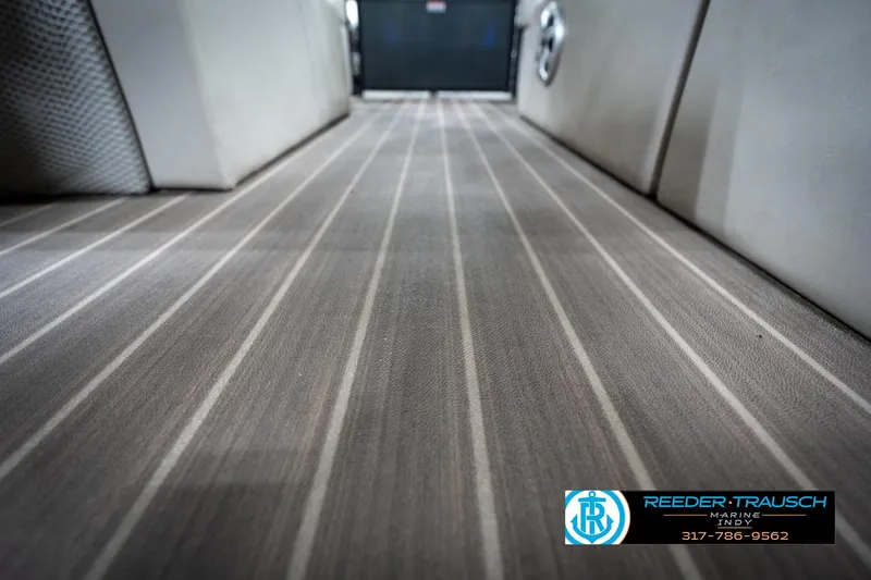 Slide: The Image of 2016 Bennington 2375 GCW boat interior with striped flooring, Reeder-Trausch Marine logo. - 49