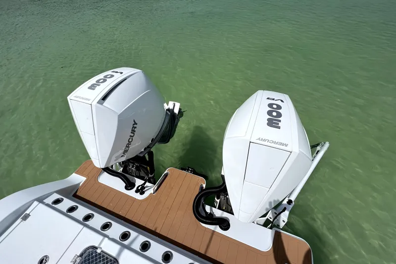 Slide: The Image of 2024 Freeman 28 boat with dual Mercury outboard engines on clear water. - 13
