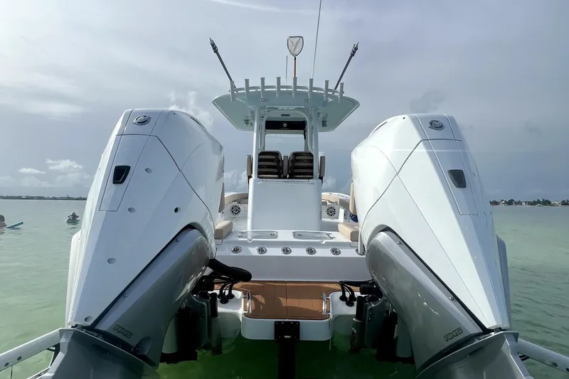 Slide: The Image of 2024 Freeman 28 boat with dual outboard engines on calm water. - 15
