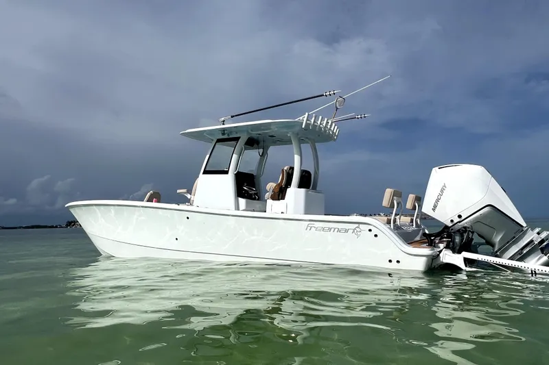 Slide: The Image of 2024 Freeman 28 boat on calm water, featuring sleek design and powerful Mercury engines. - 16