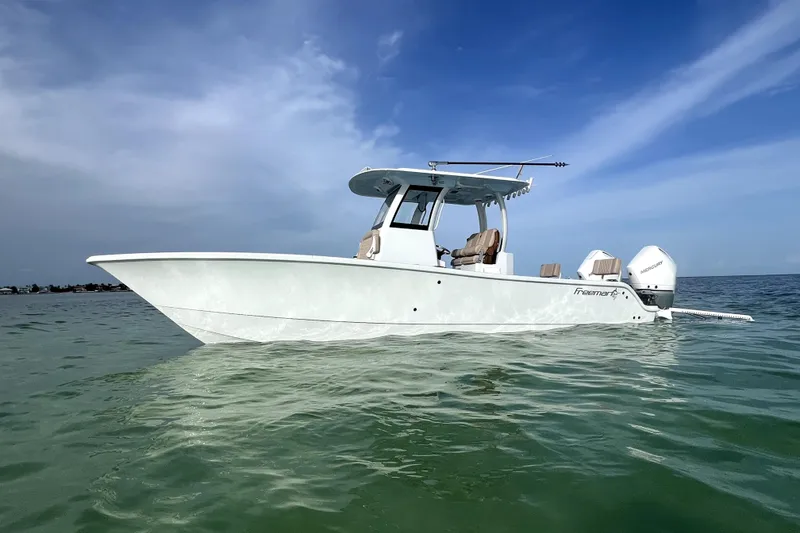 Slide: The Image of 2024 Freeman 28 boat on calm water under a clear blue sky. - 2
