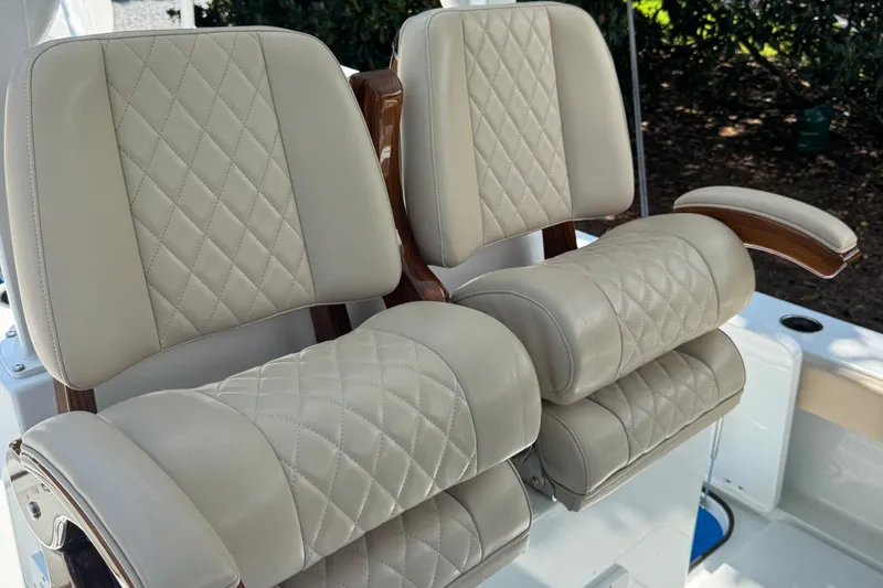 Slide: The Image of Luxurious leather seating on 2024 Freeman 28 boat, featuring diamond stitching and wooden armrests. - 21