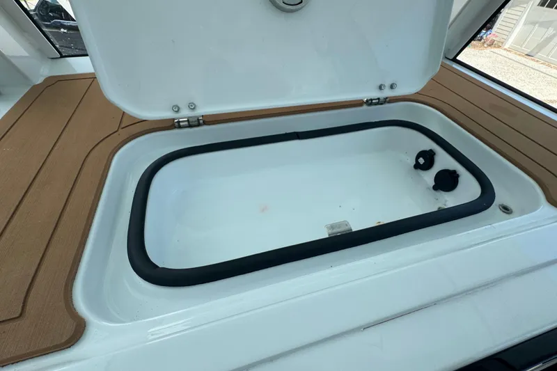 Slide: The Image of Open storage compartment on 2024 Freeman 28 boat with wooden deck accents. - 24