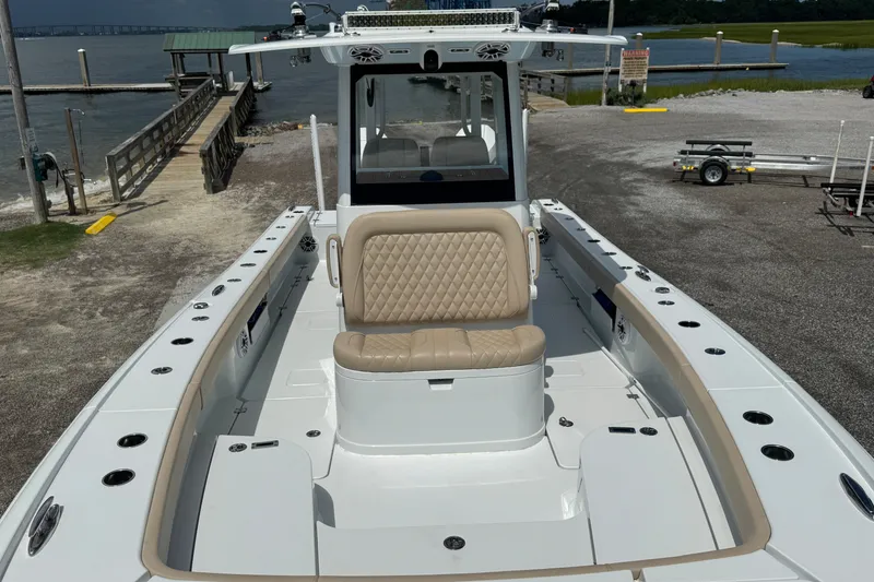 Slide: The Image of 2024 Freeman 28 boat with beige seating, docked near a waterfront. - 25