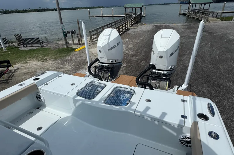 Slide: The Image of Freeman 28 boat with dual Mercury engines docked by a scenic waterfront, 2024 model. - 26