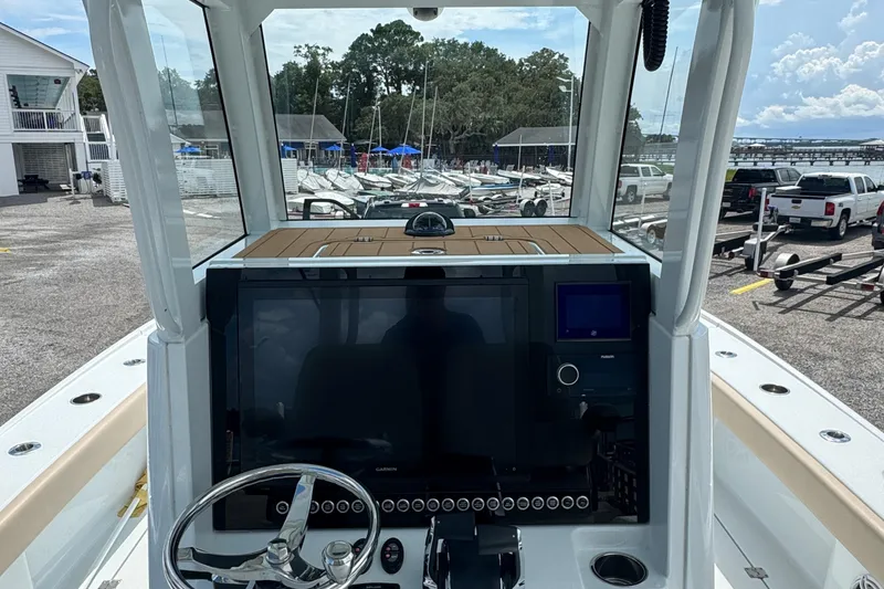 Slide: The Image of 2024 Freeman 28 boat dashboard with steering wheel and navigation screens at marina. - 28