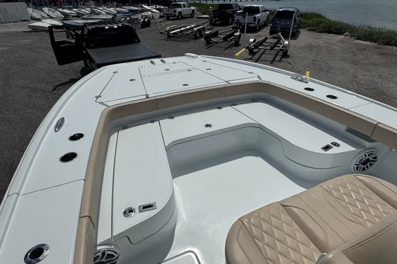 Slide: The Image of 2024 Freeman 28 boat with spacious deck and seating, parked near water. - 31