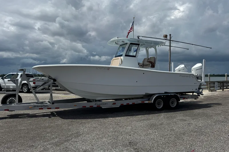 Slide: The Image of 2024 Freeman 28 boat on trailer, parked under cloudy sky. - 35