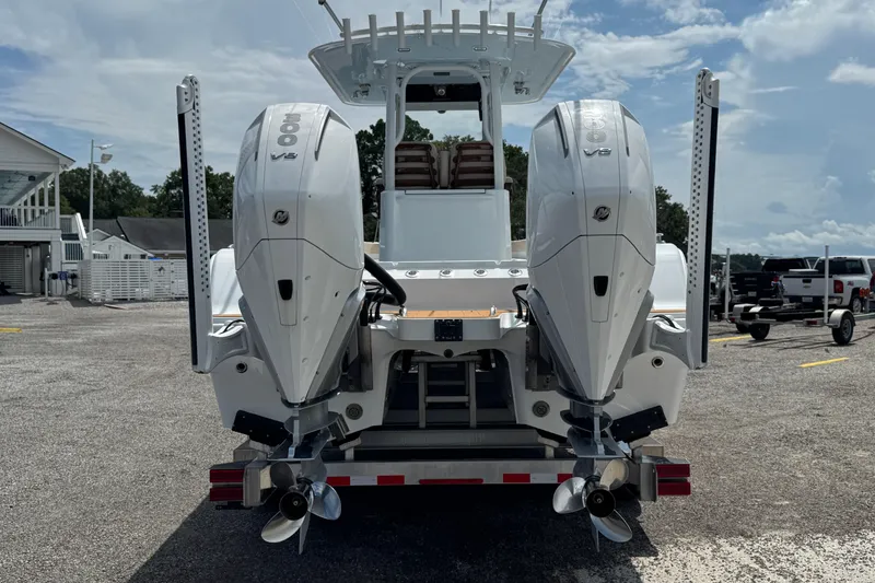 Slide: The Image of 2024 Freeman 28 boat with dual V8 engines, parked on a trailer under a clear sky. - 37