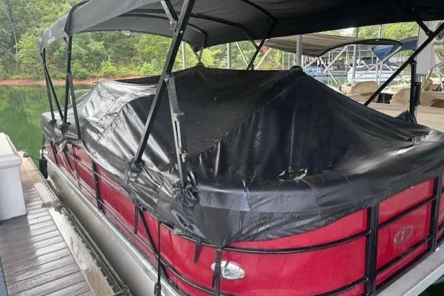 Slide: The Image of 2023 Veranda Relax VR22RC pontoon boat with black cover docked on a serene lake. - 20