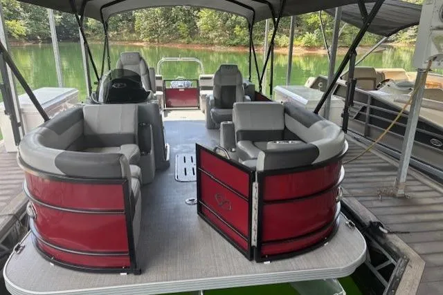 Slide: The Image of 2023 Veranda Relax VR22RC pontoon boat with red accents docked on a serene lake. - 23