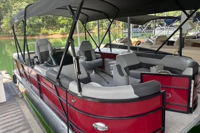 Slide: The Image of 2023 Veranda Relax VR22RC pontoon boat with red exterior and spacious seating under a canopy. - 24