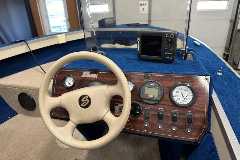 Slide: The Image of 1997 Sylvan 16 Super Select boat dashboard with steering wheel and Lowrance Elite-5 fish finder. - 12