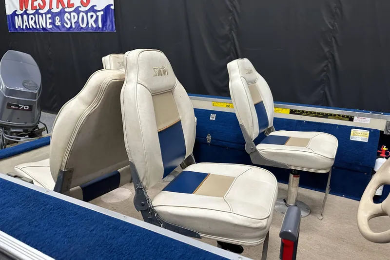 Slide: The Image of 1997 Sylvan 16 Super Select boat interior with white and blue seating. - 13