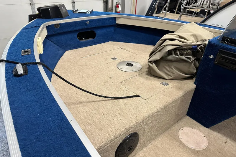 Slide: The Image of 1997 Sylvan 16 Super Select boat interior with blue and beige carpeting. - 6