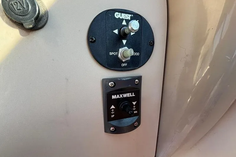 Slide: The Image of Control panel on a 2004 Sea Ray 260 Sundancer boat, featuring Guest and Maxwell switches. - 13