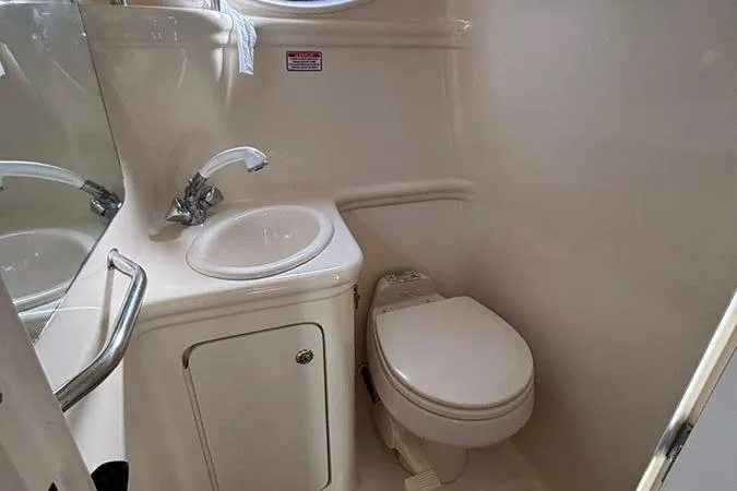 Slide: The Image of Compact bathroom in 2004 Sea Ray 260 Sundancer boat with sink and toilet. - 15