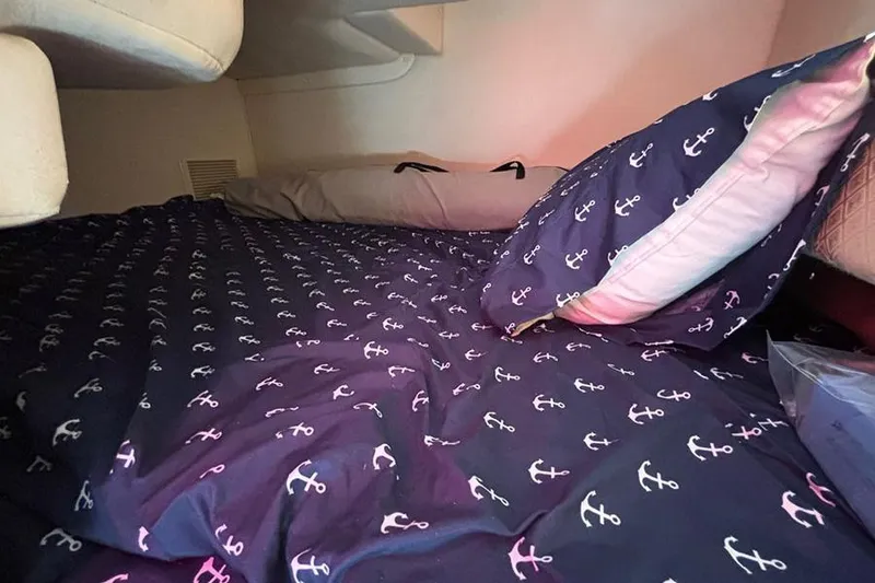 Slide: The Image of Cozy cabin interior of 2004 Sea Ray 260 Sundancer with anchor-patterned bedding. - 17