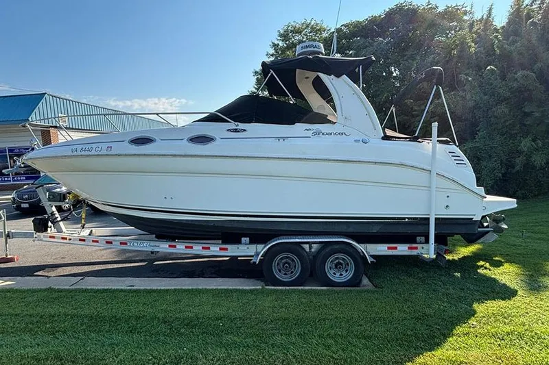 Slide: The Image of 2004 Sea Ray 260 Sundancer boat on trailer, parked on grass. - 2