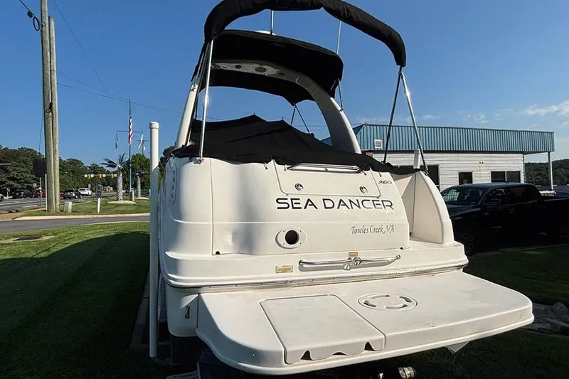 Slide: The Image of 2004 Sea Ray 260 Sundancer boat, rear view, parked outdoors under clear sky. - 3