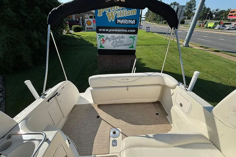 Slide: The Image of 2004 Sea Ray 260 Sundancer boat interior at Prince William Marina, featuring seating and canopy. - 5