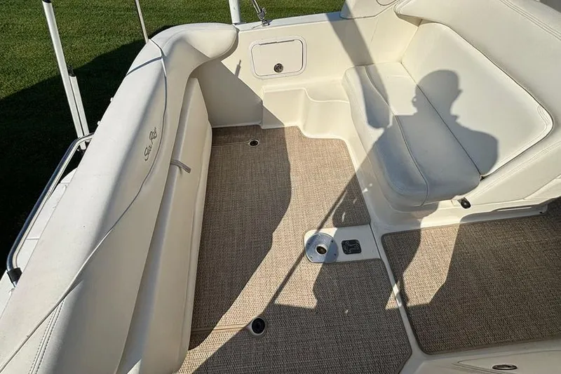 Slide: The Image of 2004 Sea Ray 260 Sundancer boat interior with beige seating and carpeted floor. - 6