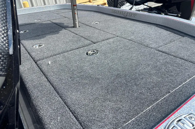 Slide: The Image of 2025 Ranger Z520R boat deck with carpeted surface and storage compartments. - 13