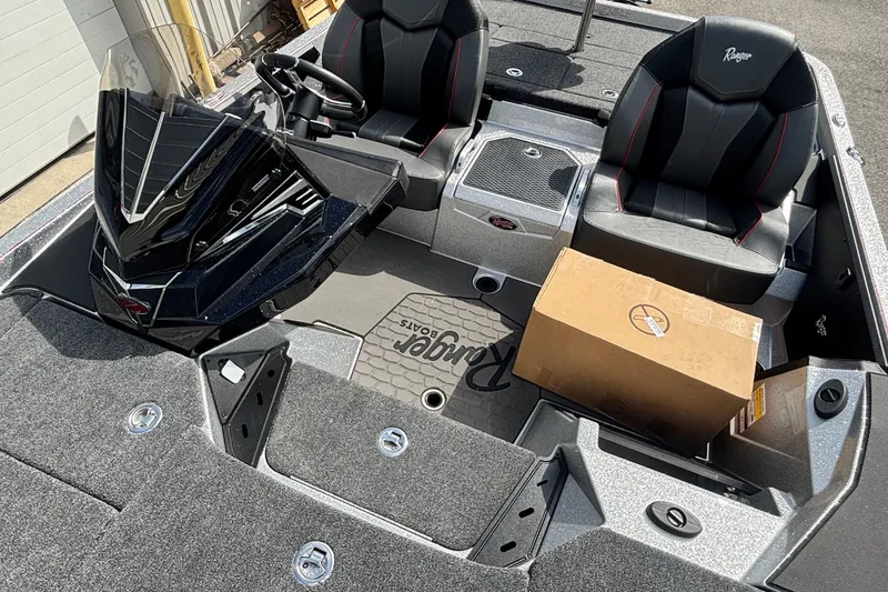 Slide: The Image of 2025 Ranger Z520R boat interior with dual seats and a cardboard box on deck. - 8