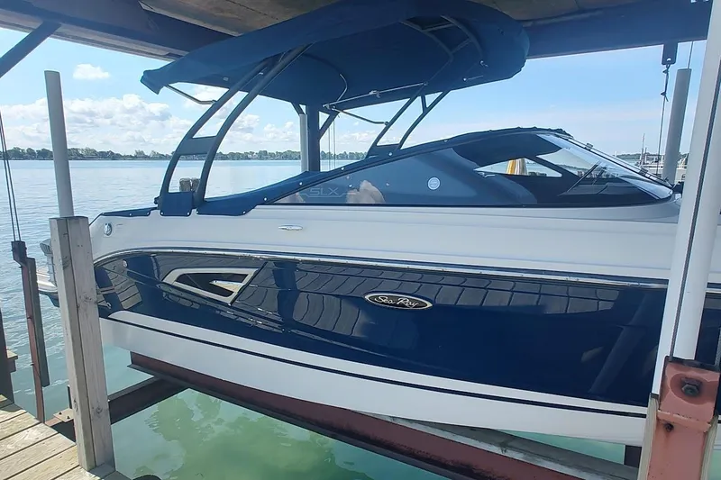 Slide: The Image of 2017 Sea Ray SLX 230 boat docked, featuring sleek design and blue exterior. - 2
