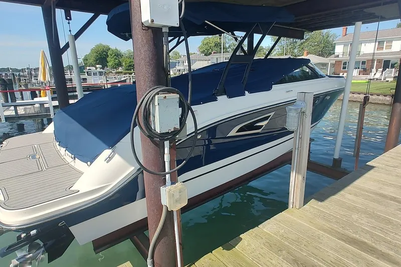 Slide: The Image of 2017 Sea Ray SLX 230 boat docked with blue cover in a marina setting. - 3