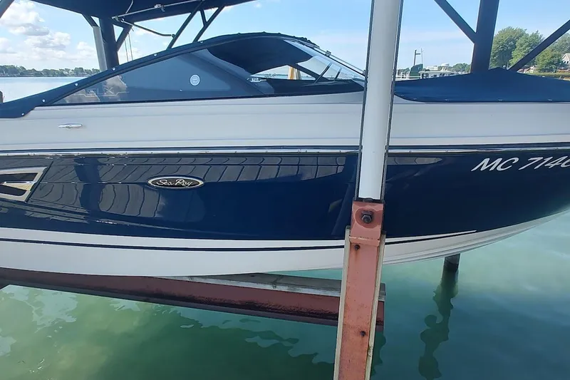 Slide: The Image of 2017 Sea Ray SLX 230 boat docked, featuring sleek blue and white design. - 4