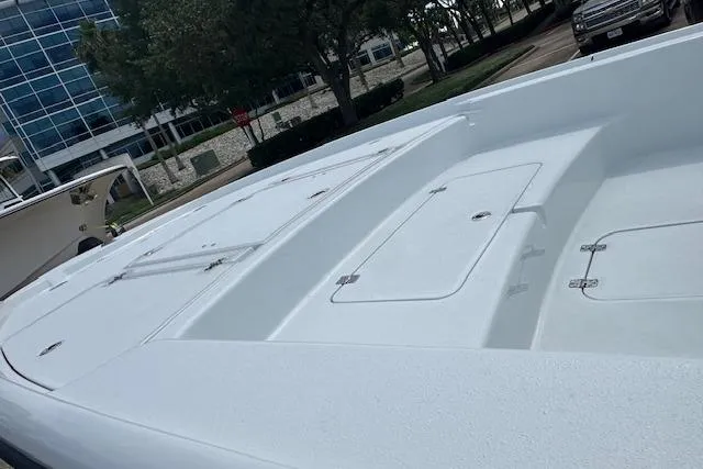 Slide: The Image of 2026 Yellowfin 24 CE boat with white seating and Mercury engine in a parking lot. - 13